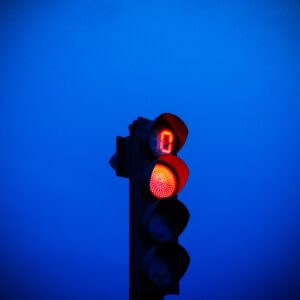Photo of a red traffic light against a blue background